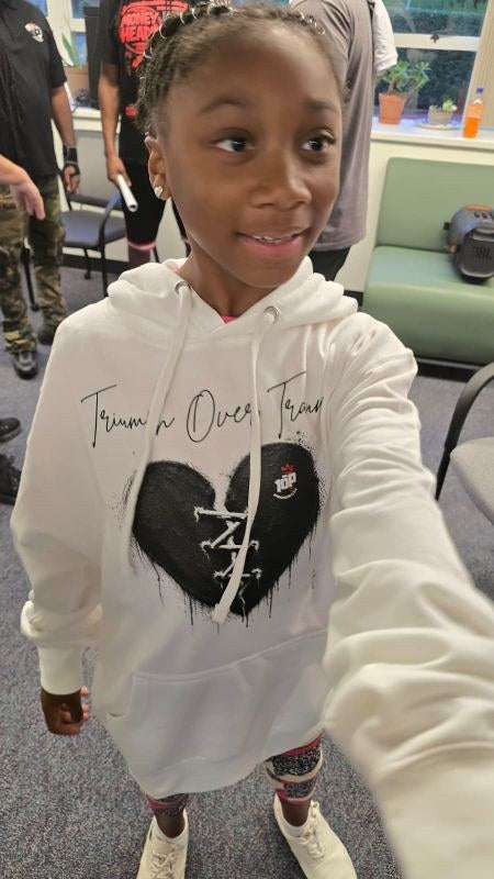 Young member wearing the white Triumph Over Trauma hoodie